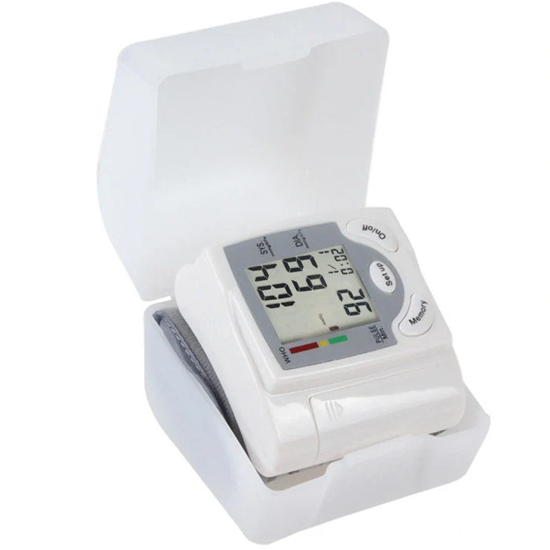 White wrist blood pressure monitor with digital display showing blood pressure readings and adjustable cuff