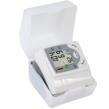 White wrist blood pressure monitor with digital display showing blood pressure readings and adjustable cuff