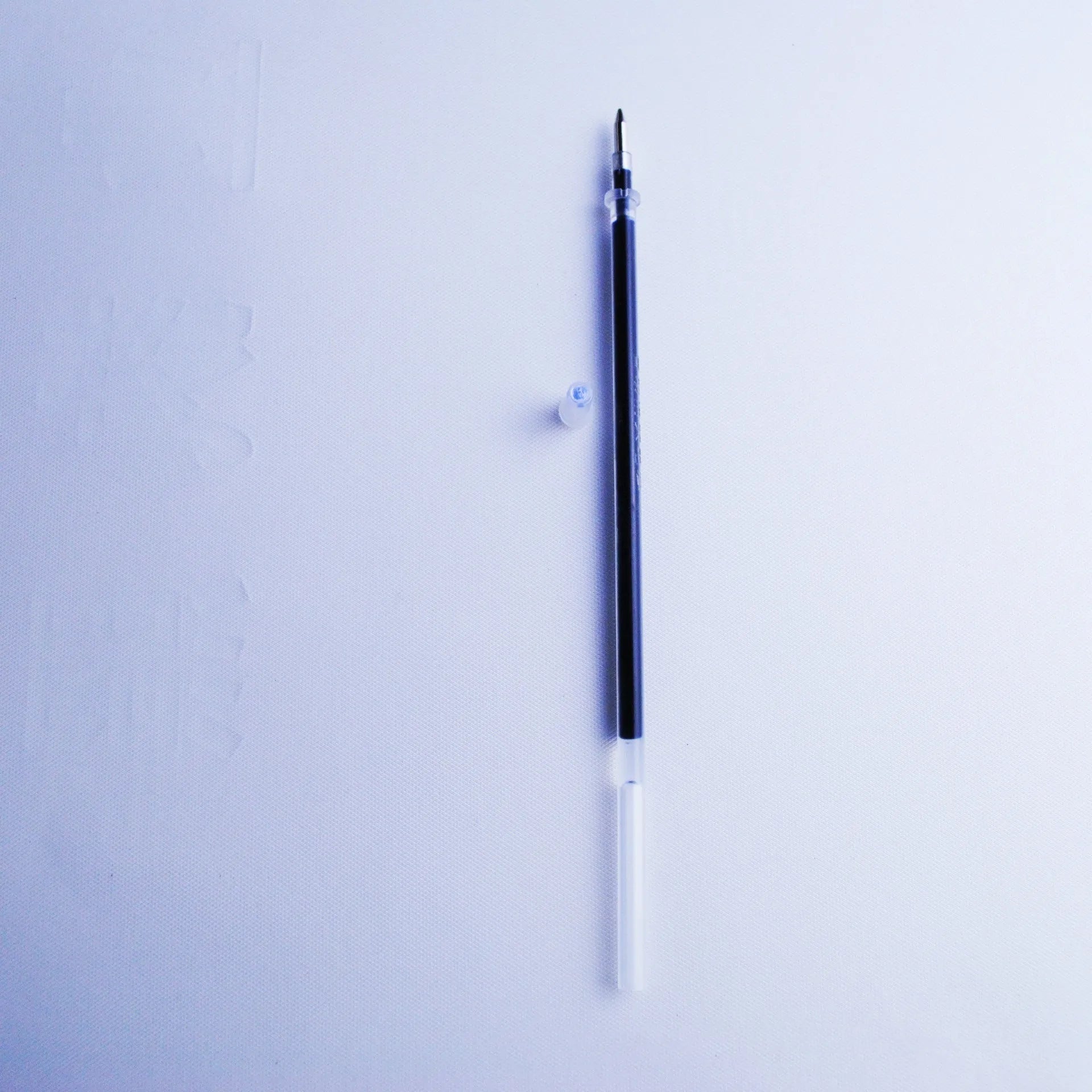 Automatic fading pen set showing blue refills, a plastic pen, and a storage holder.
