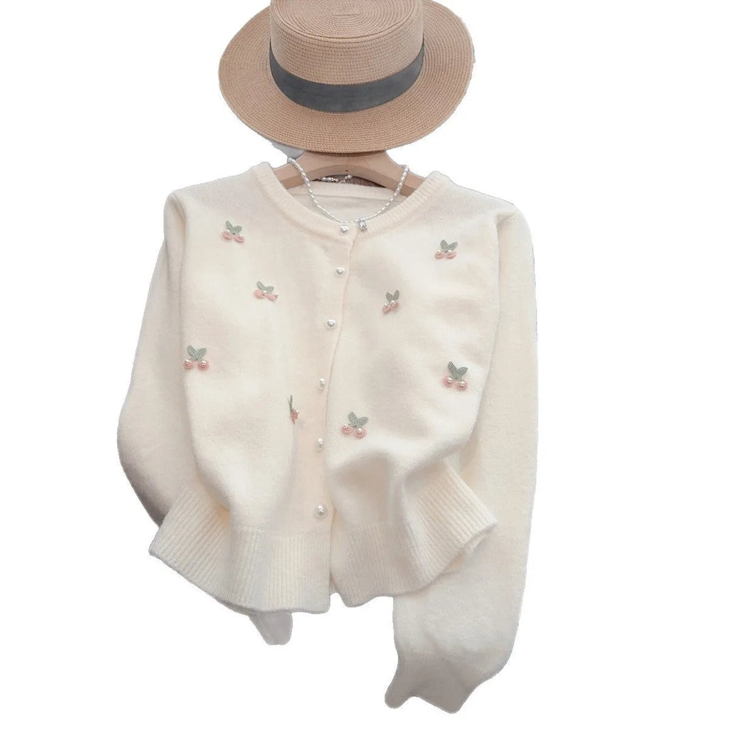 Women's soft pink cashmere blend cardigan coat with beaded detail and round neck, laid flat.
