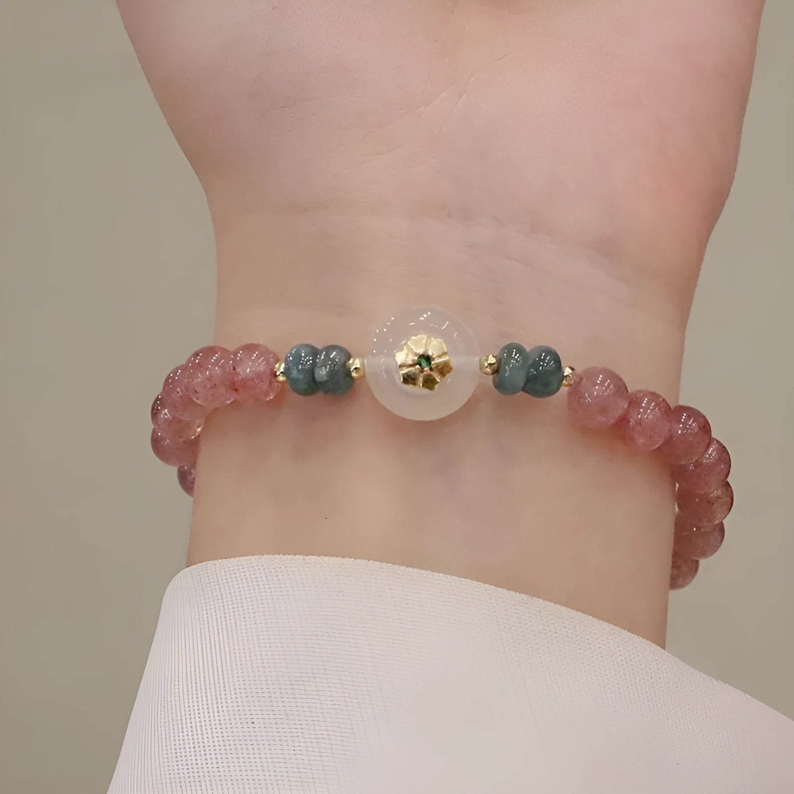 Women's strawberry quartz bracelet with blue water emerald stones and round jade pendant on geometric chain