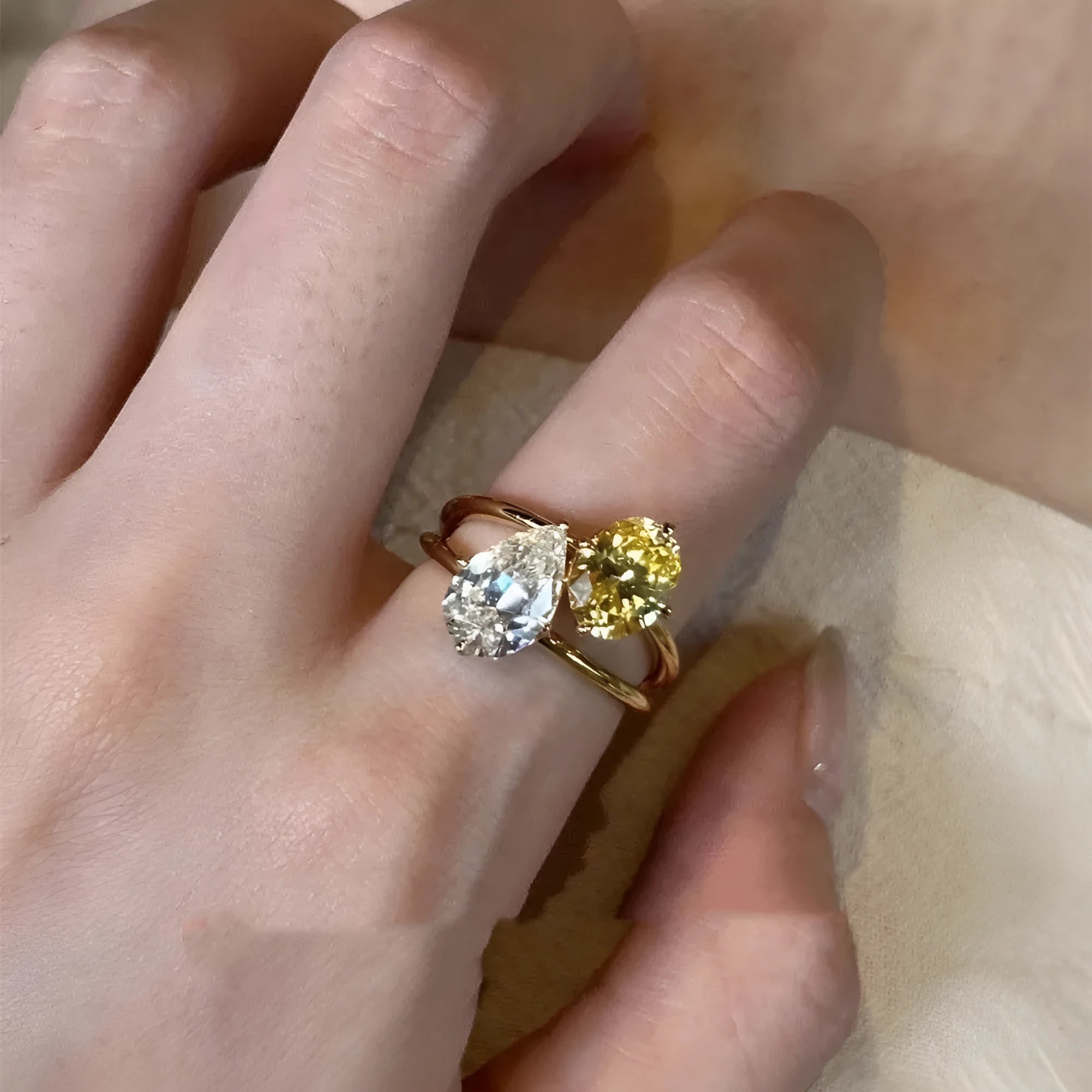 Copper geometric open ring with water drop design and two small set stones on a white background.