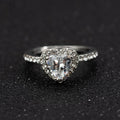 Women's heart-shaped wedding ring with central crystal on white copper band in rose gold finish.