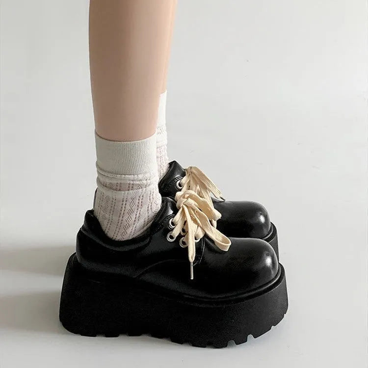 Matte black women's lace-up platform shoes with thick rubber sole and retro block heel.