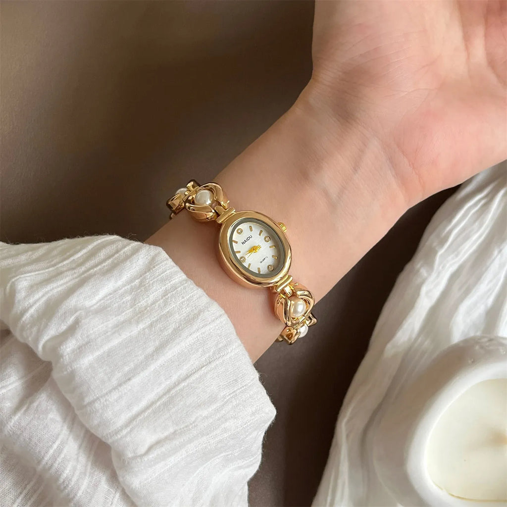 Women's quartz watch with alloy bracelet and pointer display, gold strap black surface