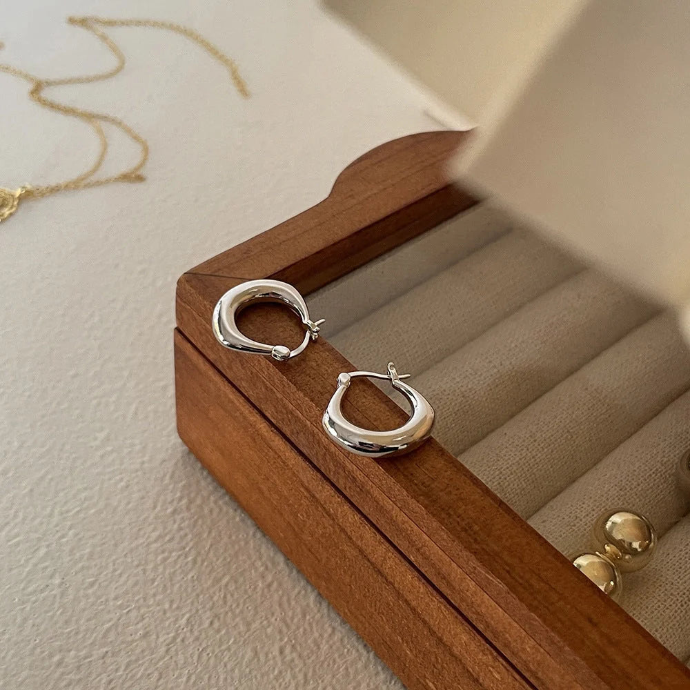 Small fat circle ear clips in white gold and yellow gold finishes for women