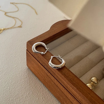 Small fat circle ear clips in white gold and yellow gold finishes for women