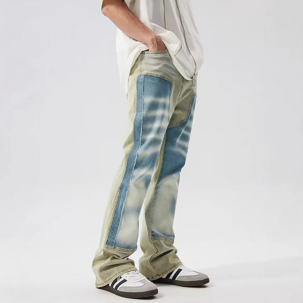 Yellow and blue retro patchwork jeans with splash-ink distressed design on a mid-waist trouser cut.