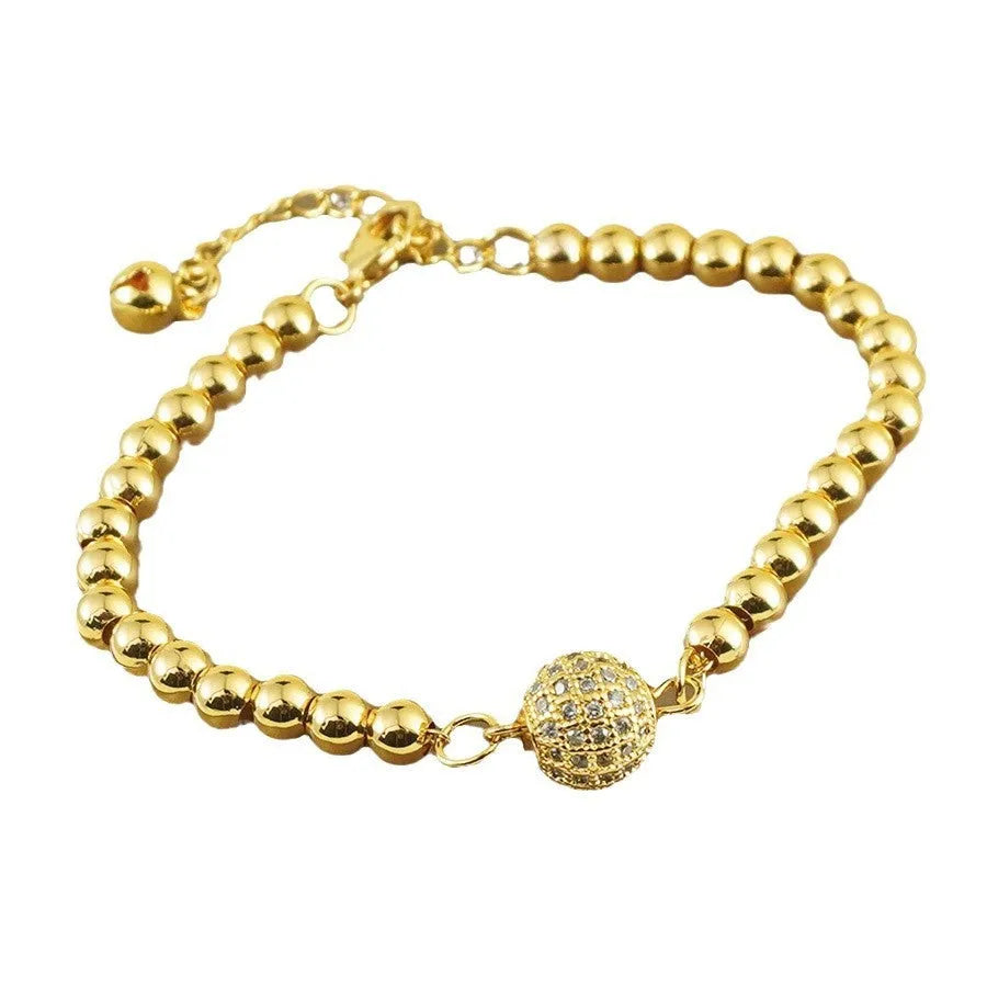 Close-up of a women's copper bracelet with a heart-shaped charm holding a round zircon stone, Arabic style design.