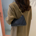 Brown pleated chain strap baguette shoulder bag showing vertical square shape and soft handle.