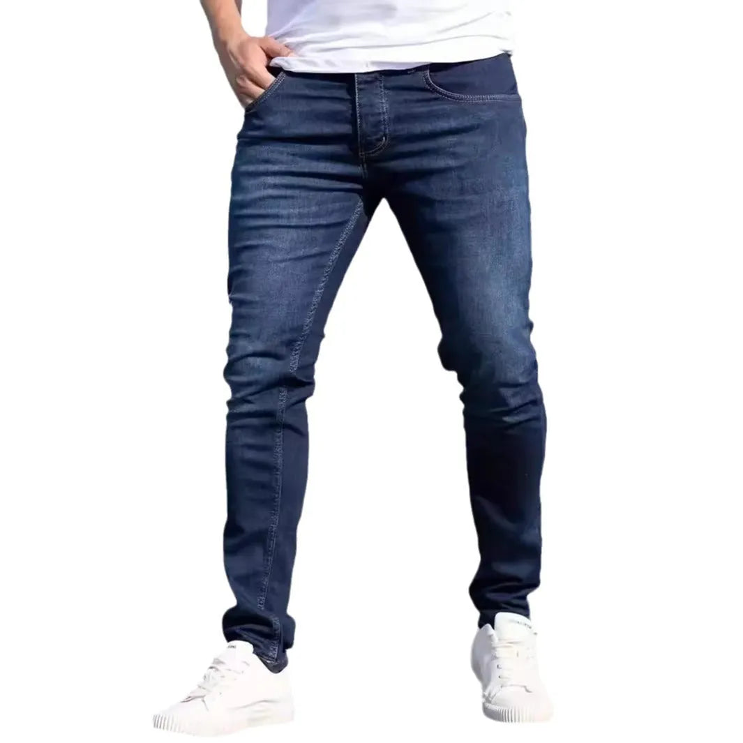 Men's dark blue slim-fit elastic cotton jeans with a skinny leg opening.