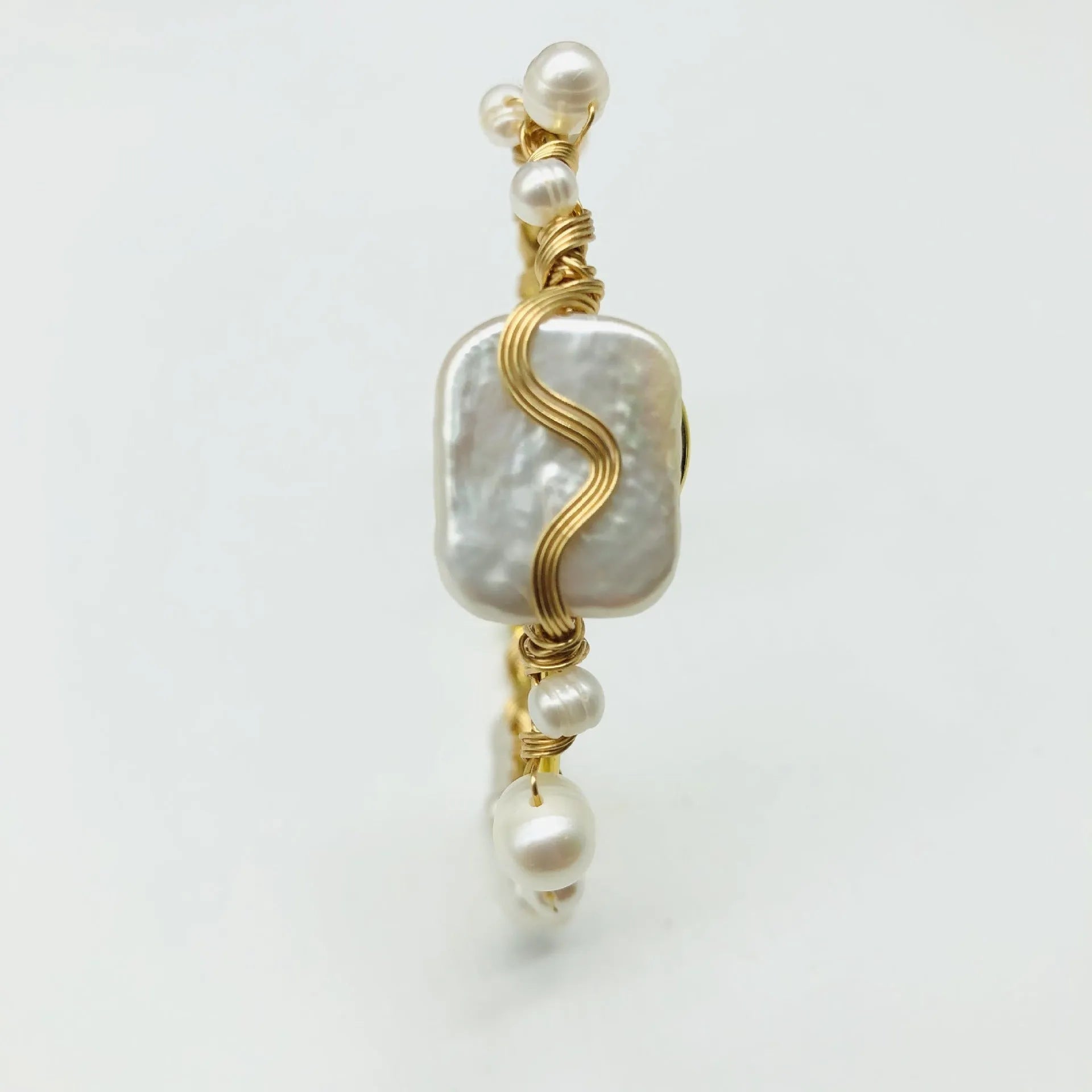 Natural freshwater pearl bracelet with gold titanium steel wire-wrap on hand model