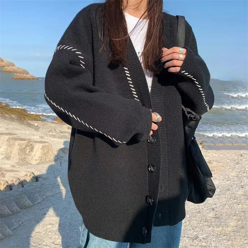 Women's loose fit long sleeve knitted cardigan coat in black or white.