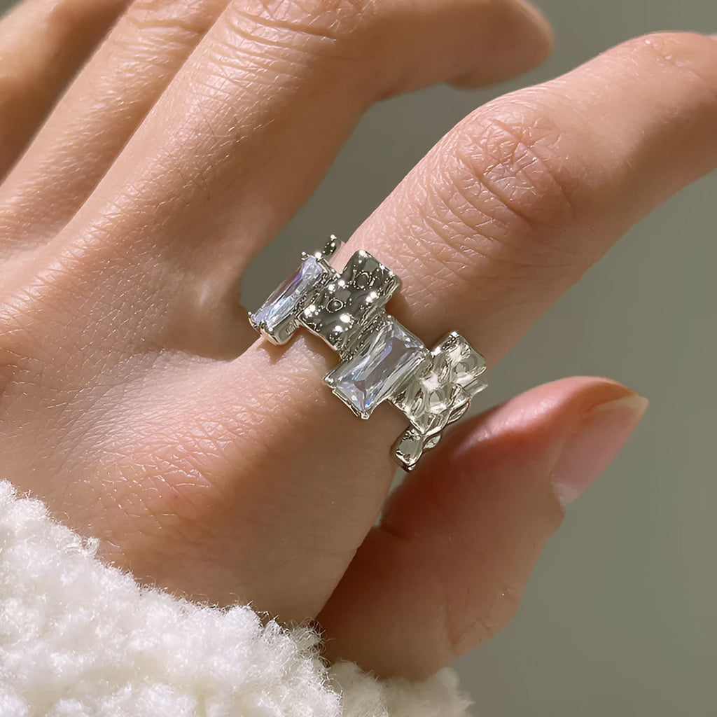Silver geometric cross ring with open gemstone setting and retro national fashion decorative elements.