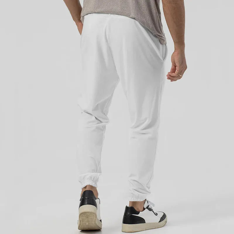 Men's grey cotton blend track sweatpants with a loose tapered fit and straight leg on a mannequin.