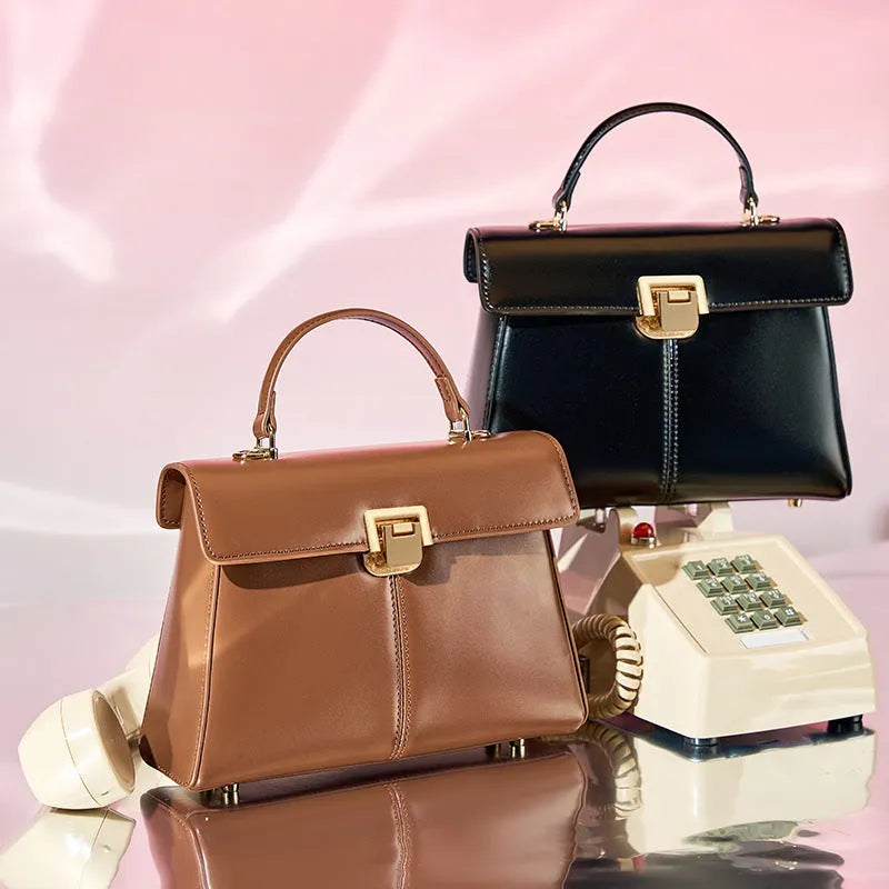 Black genuine leather women's shoulder bag with vachette clasp and long strap.