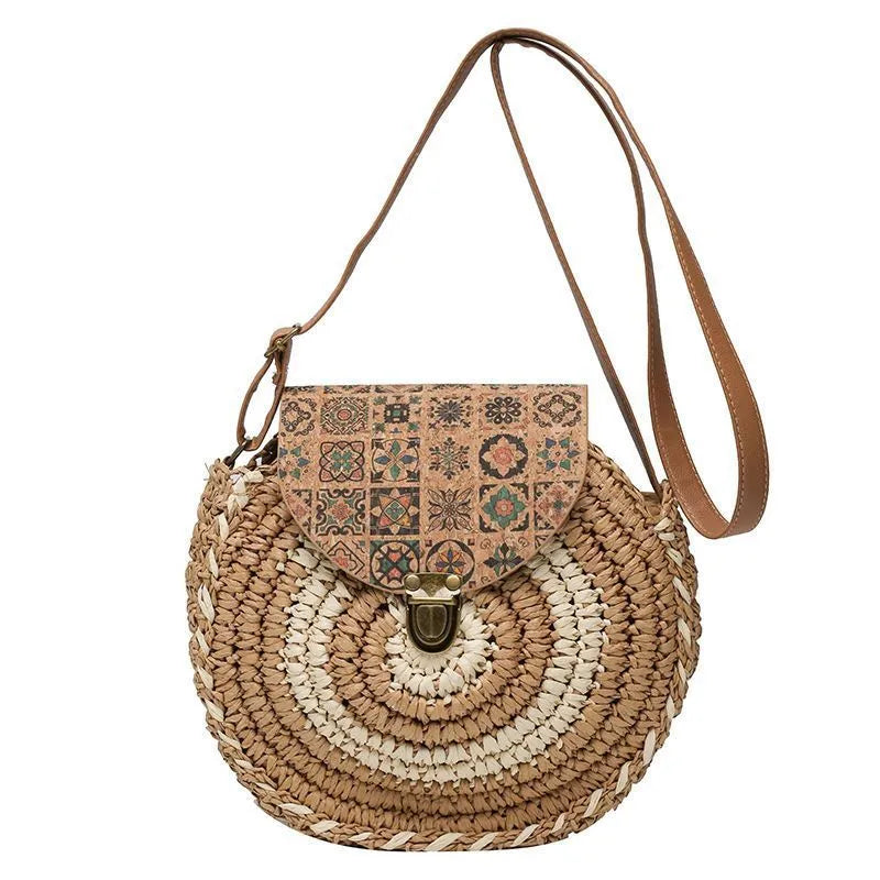 Round straw woven crossbody bag in beige, 25cm diameter, with adjustable shoulder strap, displayed on a neutral background