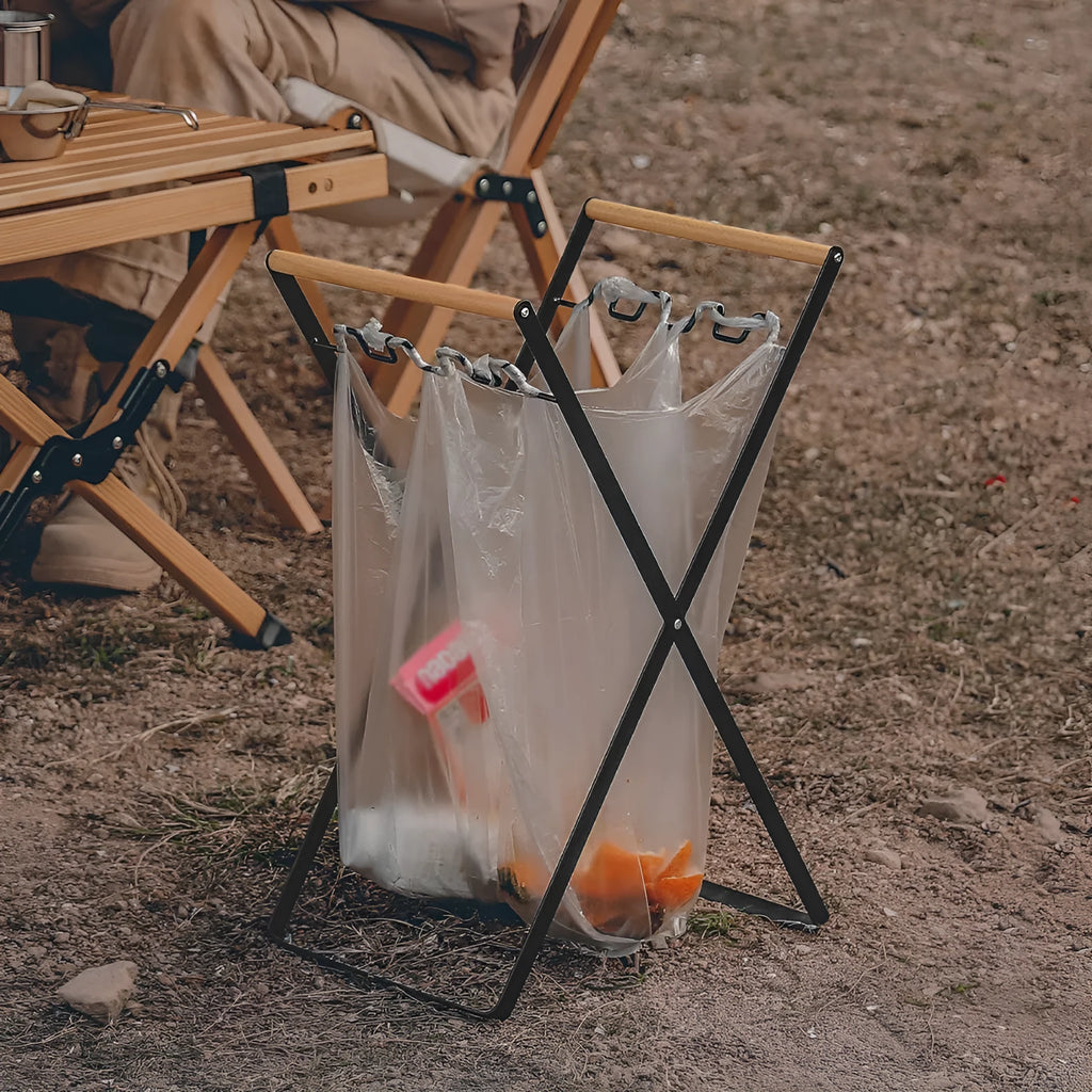 Foldable outdoor garbage storage hanger with iron frame and wooden handle in black colour.