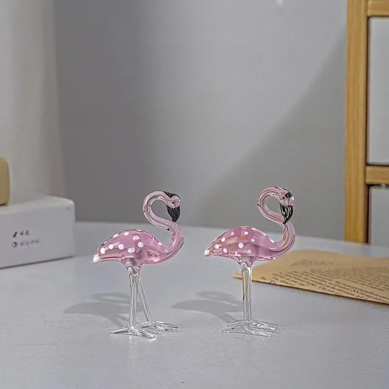 A pink flamingo decorative ornament made from clear white crystal on a table.