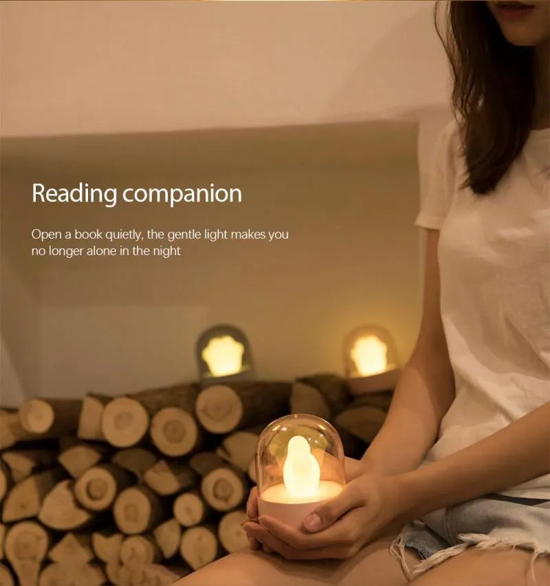 Grey cat paw shaped USB rechargeable night light with music box feature on wooden desk