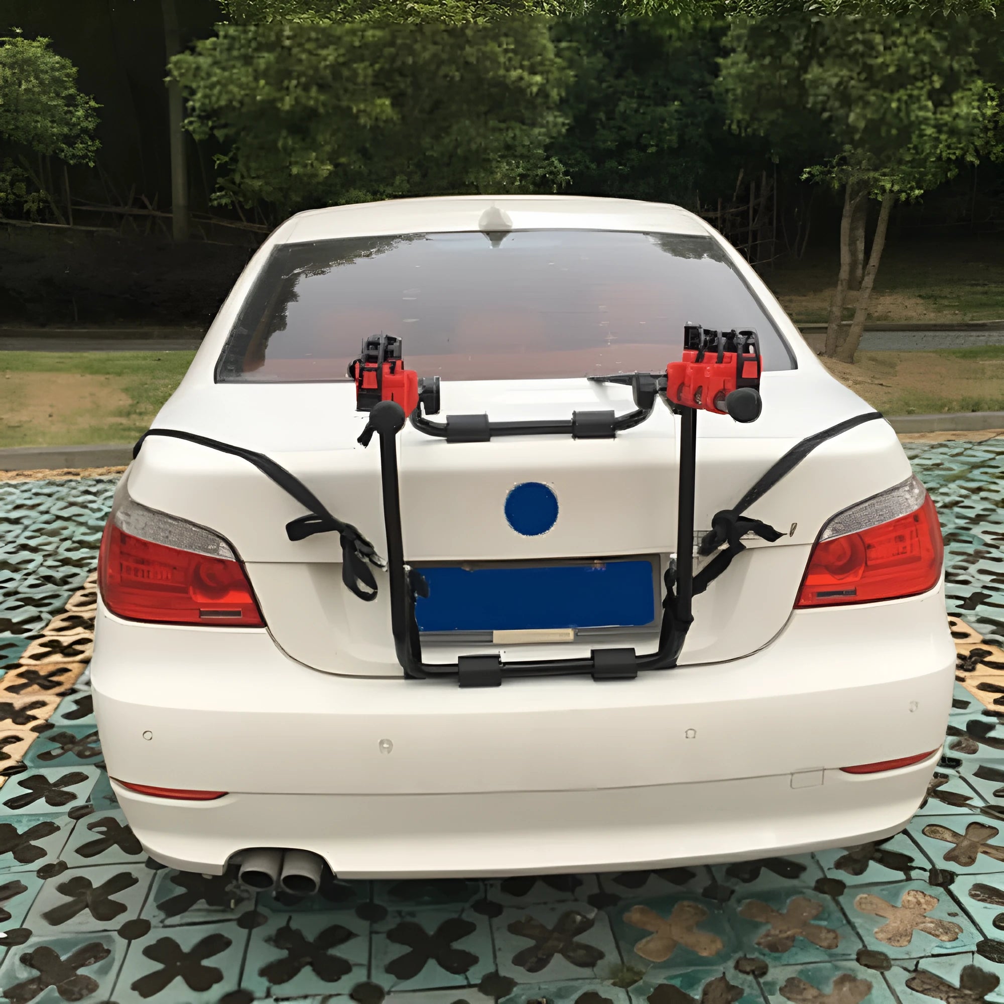 Black and red trunk-mounted car bike rack with iron frame, shown with tie rope fastenings.