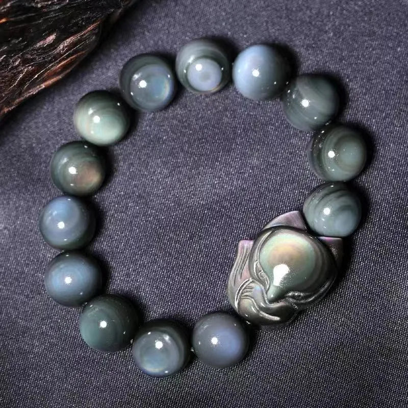 Black obsidian stone bracelet with carved fox design in cartoon style, showing texture and adjustable sizing