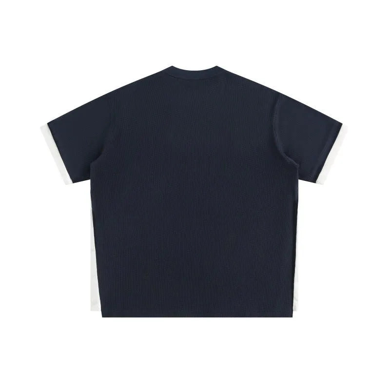 Loose waffle-knit short-sleeved t-shirt with retro alphabet embroidery on the front, shown in navy blue.