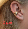 A pair of gold drop earrings featuring a detailed starfish and conch design on an alloy base.