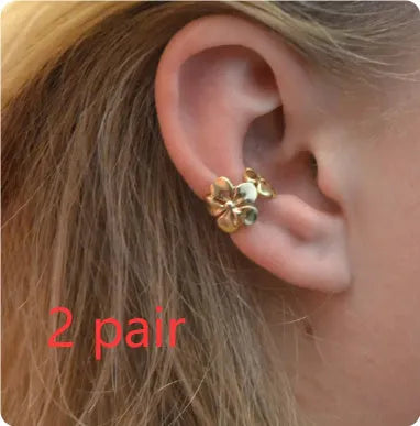 A pair of gold drop earrings featuring a detailed starfish and conch design on an alloy base.