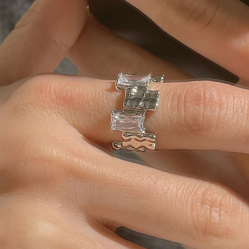 Silver geometric cross ring with open gemstone setting and retro national fashion decorative elements.