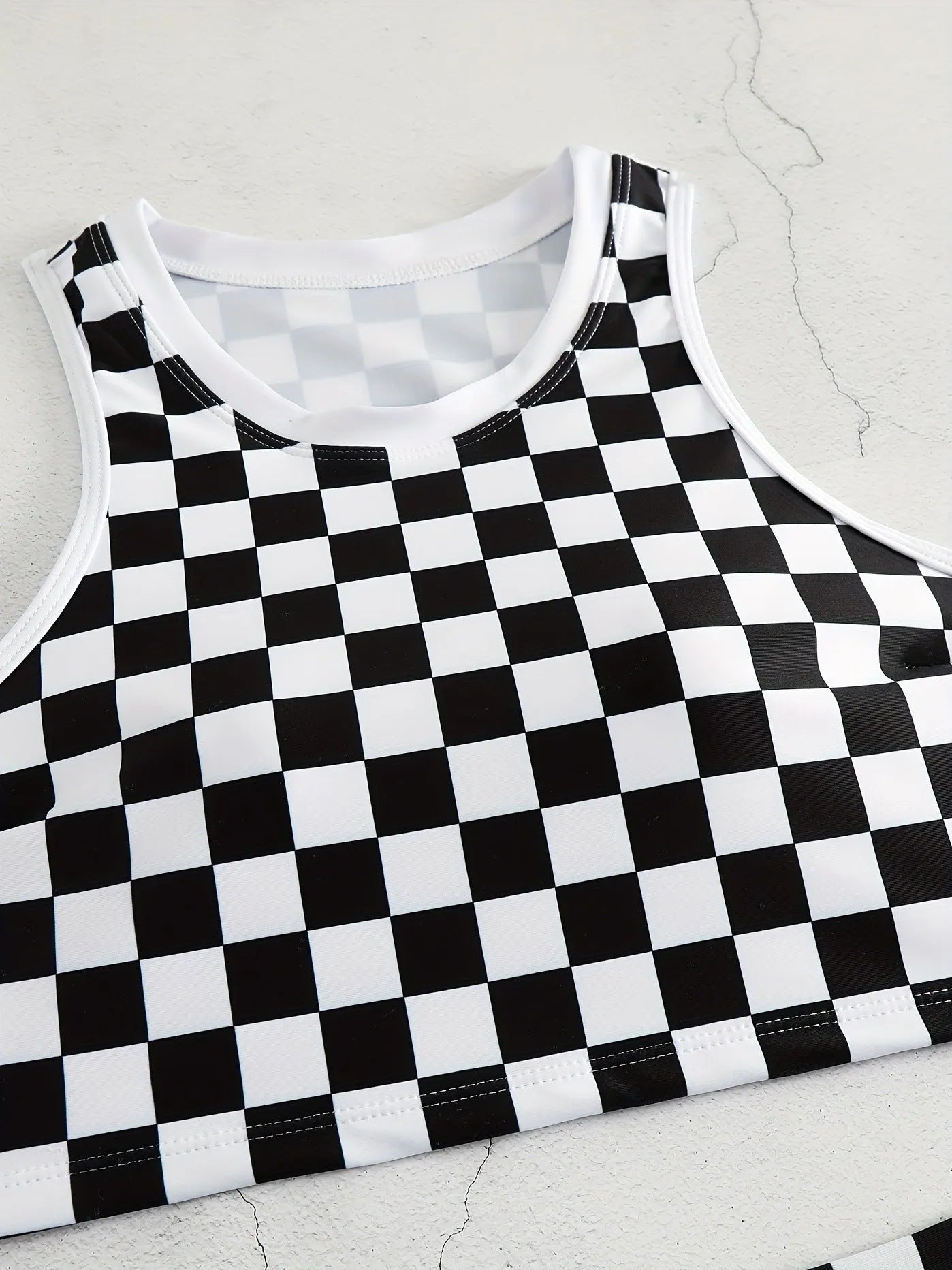 Women's black and white chessboard plaid racing one-piece swimsuit with a suspender backless design.