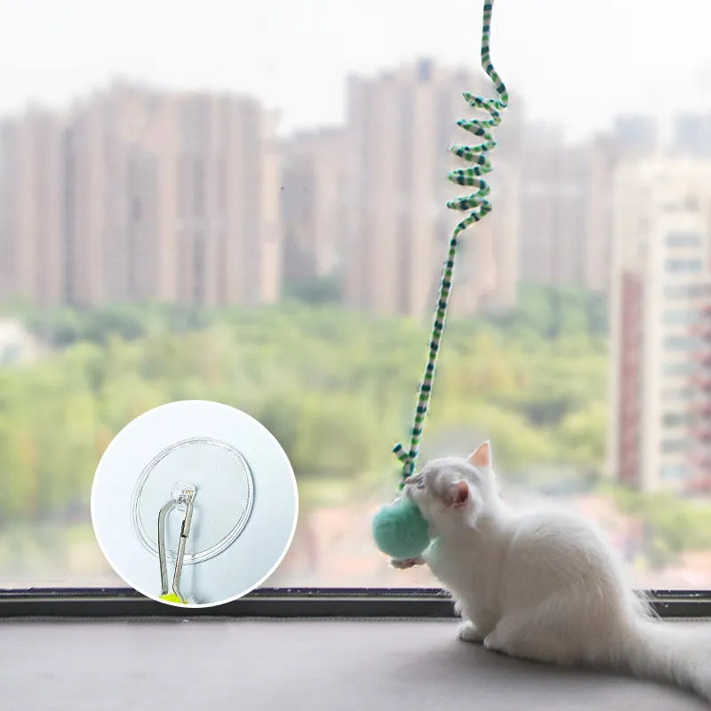 Colourful cat toy with inflatable ball and bell stick hanging from suction cup on door