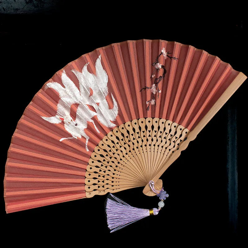 Bamboo folding fan with silk embroidery showing traditional Chinese patterns