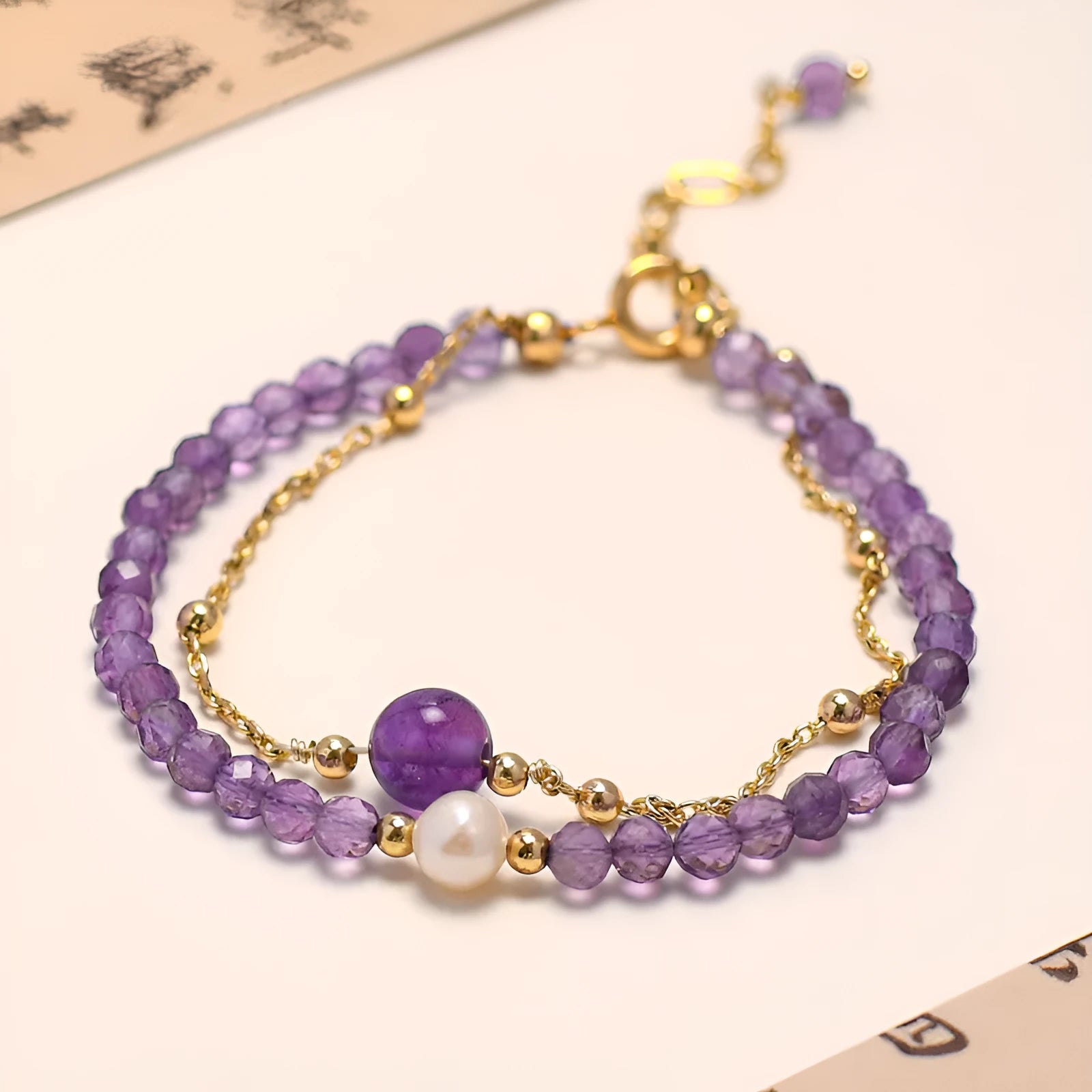 Close-up of a women's amethyst bracelet with diamond-cut crystal beads and Chinese style design.