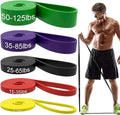 Set of five TPE resistance bands in yellow, red, black, purple, and green on a wooden floor