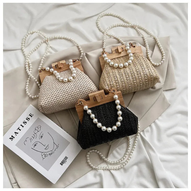 Women's woven straw shoulder bag with pearl chain detail, shown in beige, featuring internal organiser pockets.