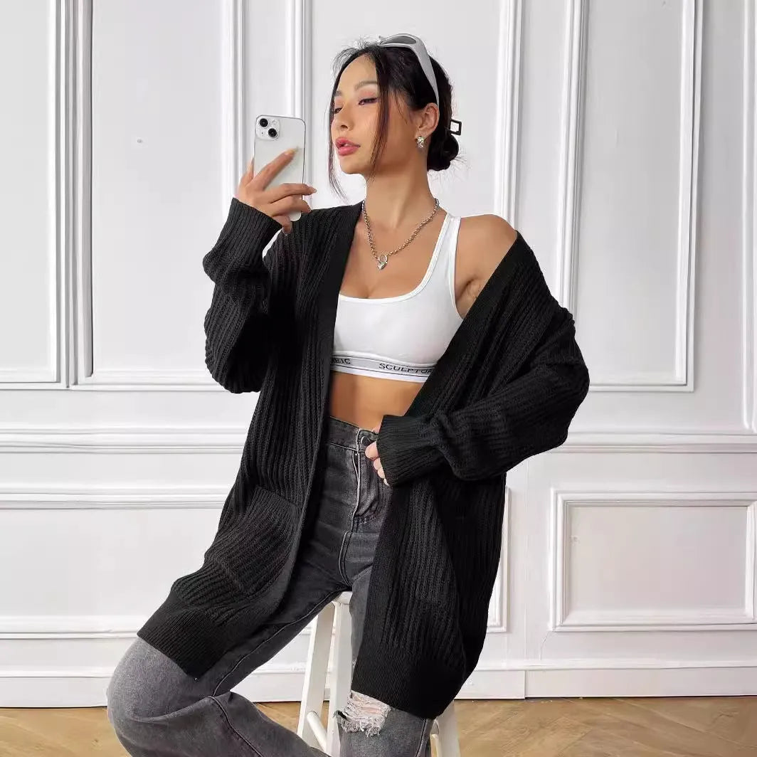 Women's dark green loose-fit acrylic cardigan sweater with double pockets and long sleeves.