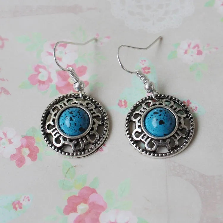 Handmade geometric flower disk earrings in Tibetan silver and turquoise with ethnic patterns.