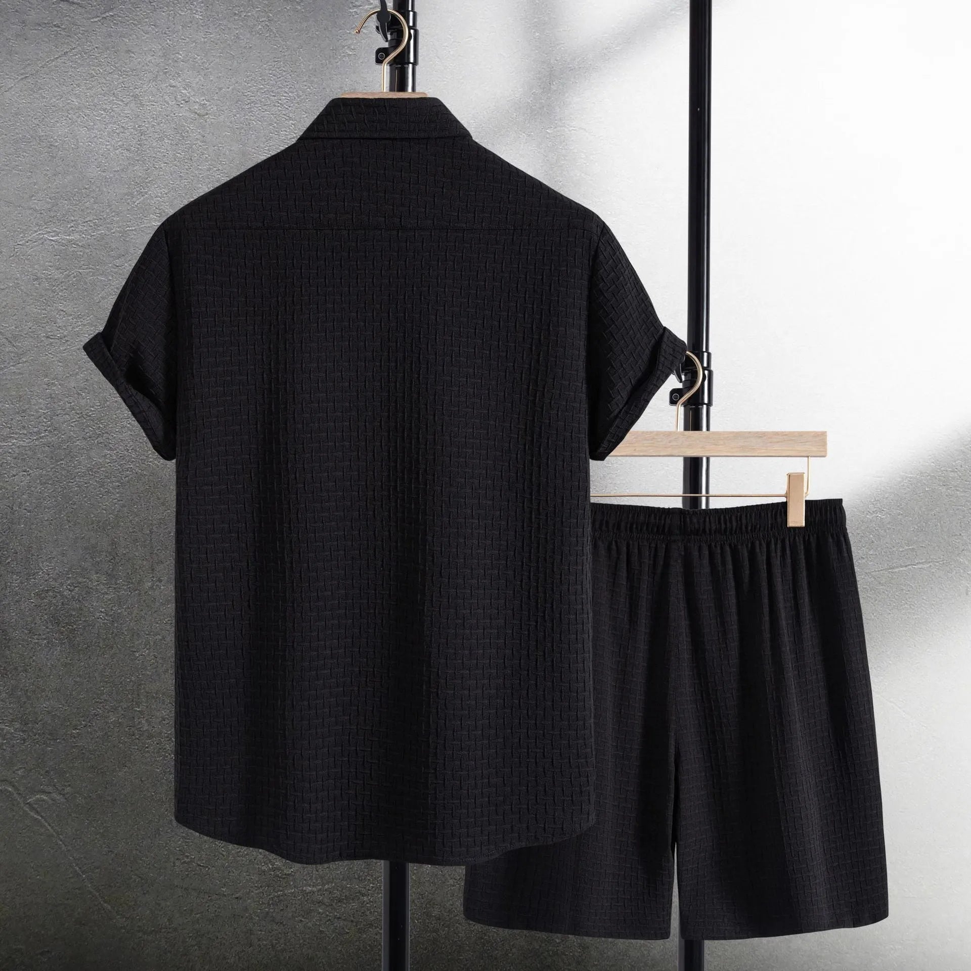 Men's black cotton blend short sleeve shirt and matching shorts casual suit laid flat.