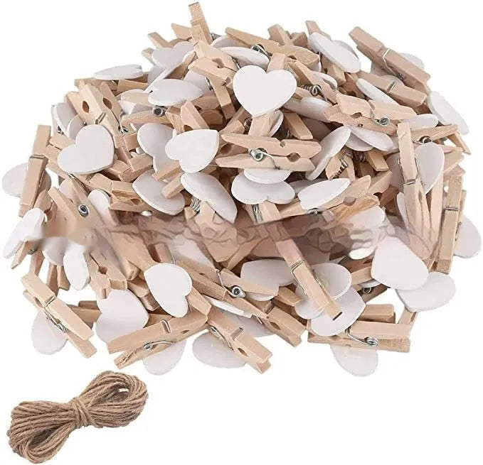 Set of five small red, pink, and white solid wood heart-shaped clips on a surface.