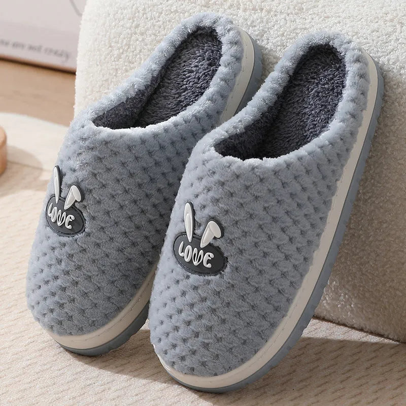 Rabbit plaid design artificial fur house slippers with a non-slip rubber sole.