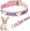 Reflective soft PU leather dog collar with metal buckle and decorative paw print rivets on a grey background.