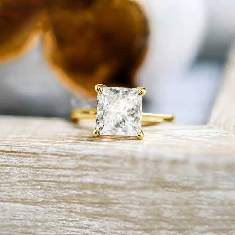 A polished geometric sterling silver ring for women on a grey background.