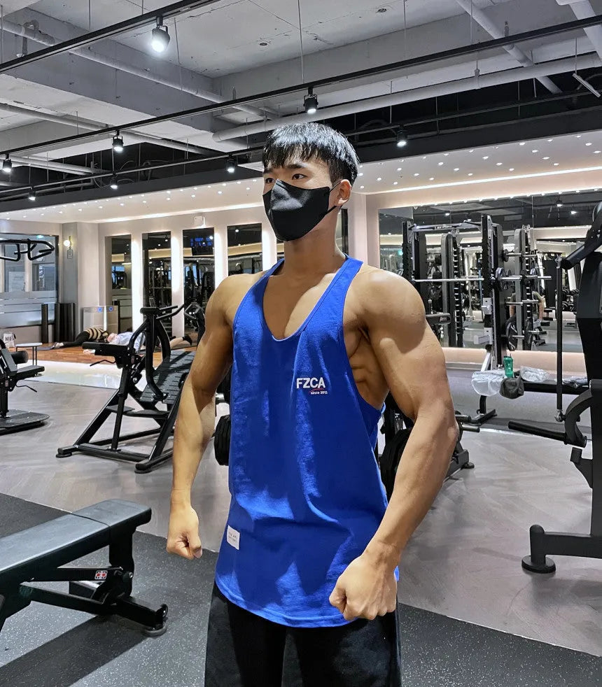 Men's white cotton sports vest for fitness and running training, shown on a hanger.