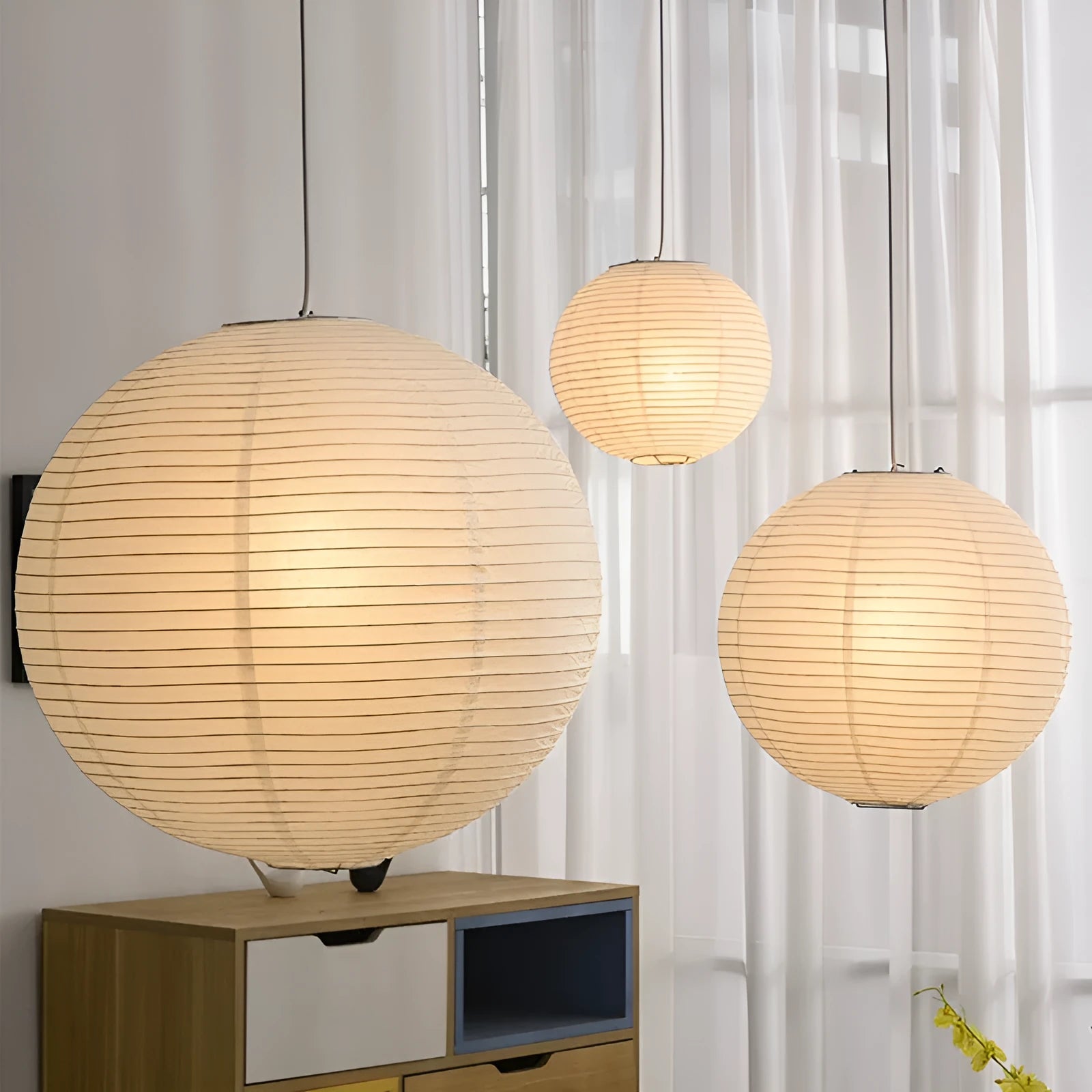 Modern paper pendant ceiling lamp with three colour light source shown in a living room setting
