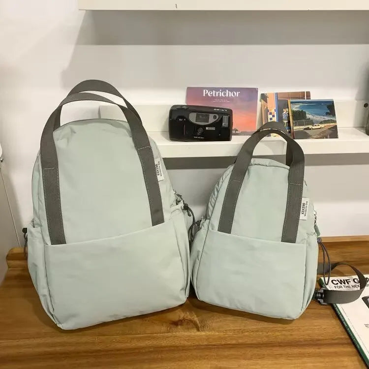 Solid colour ultra-light waterproof nylon backpack with curved shoulder straps on a white background
