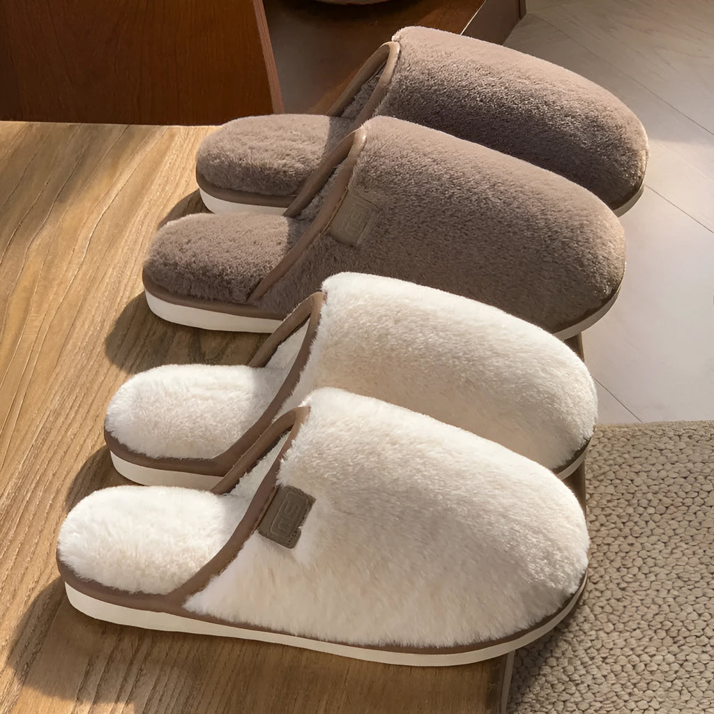 Blue plush slipper with non-slip PVC sole and car-stitching detail on a wooden floor.