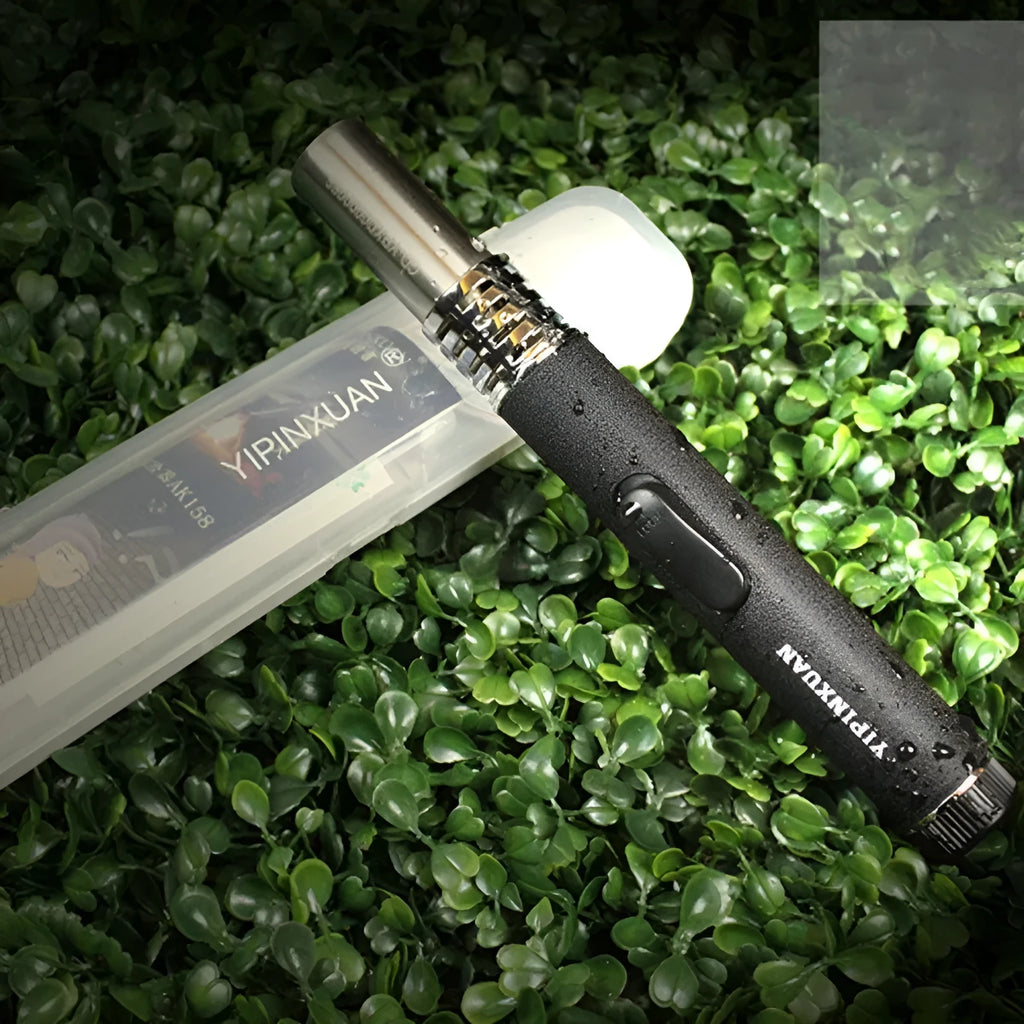 Black portable metal flamethrower torch with frosted finish and child lock, shown with gas bottles for outdoor use.