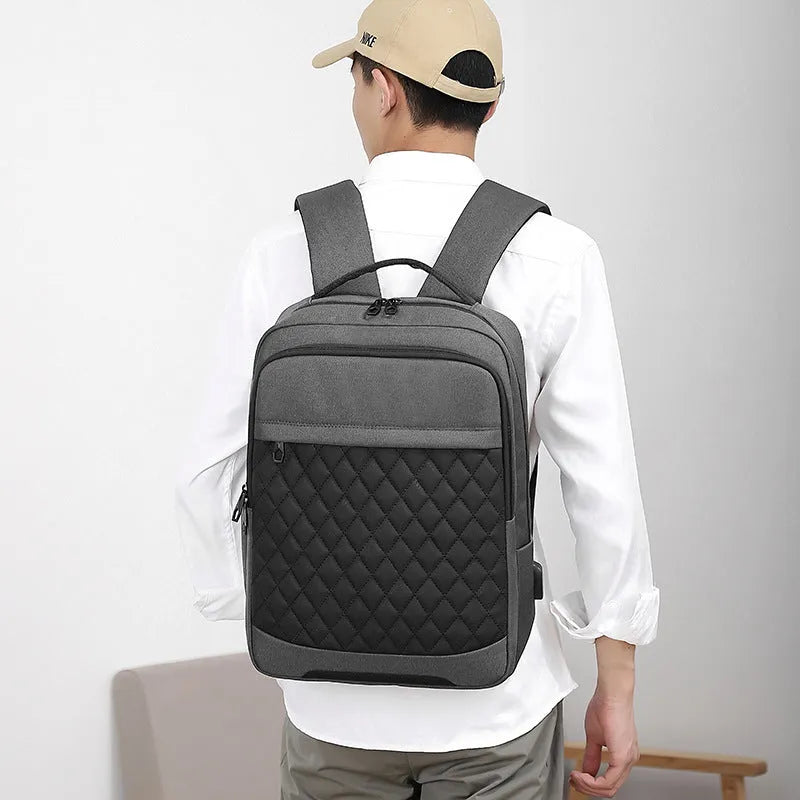 Men's Oxford cloth travel backpack in black showing curved shoulder strap and diamond mesh back panel