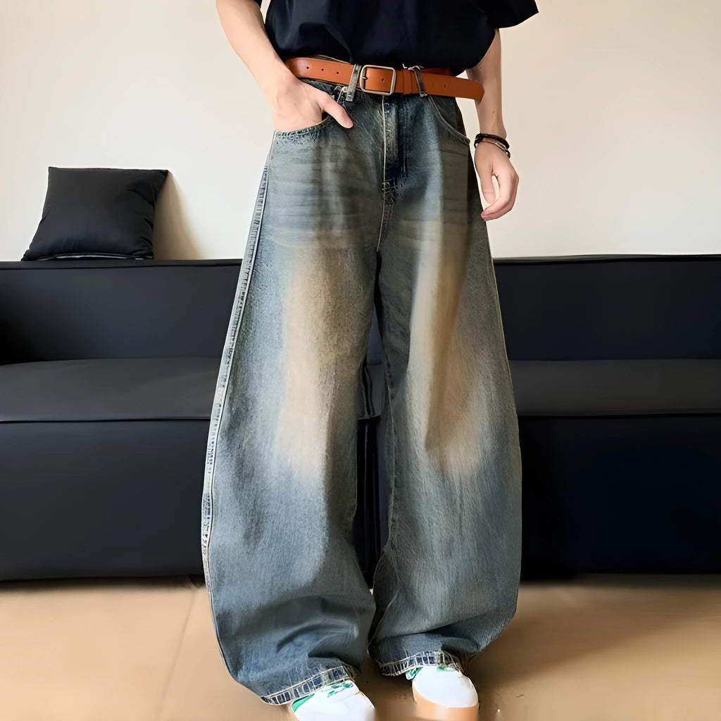 Men's retro blue distressed denim jeans with a slimming wide-leg fit and machete wash detail.